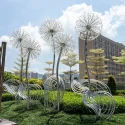 Outdoor park square green space glowing stainless steel dandelion sculpture